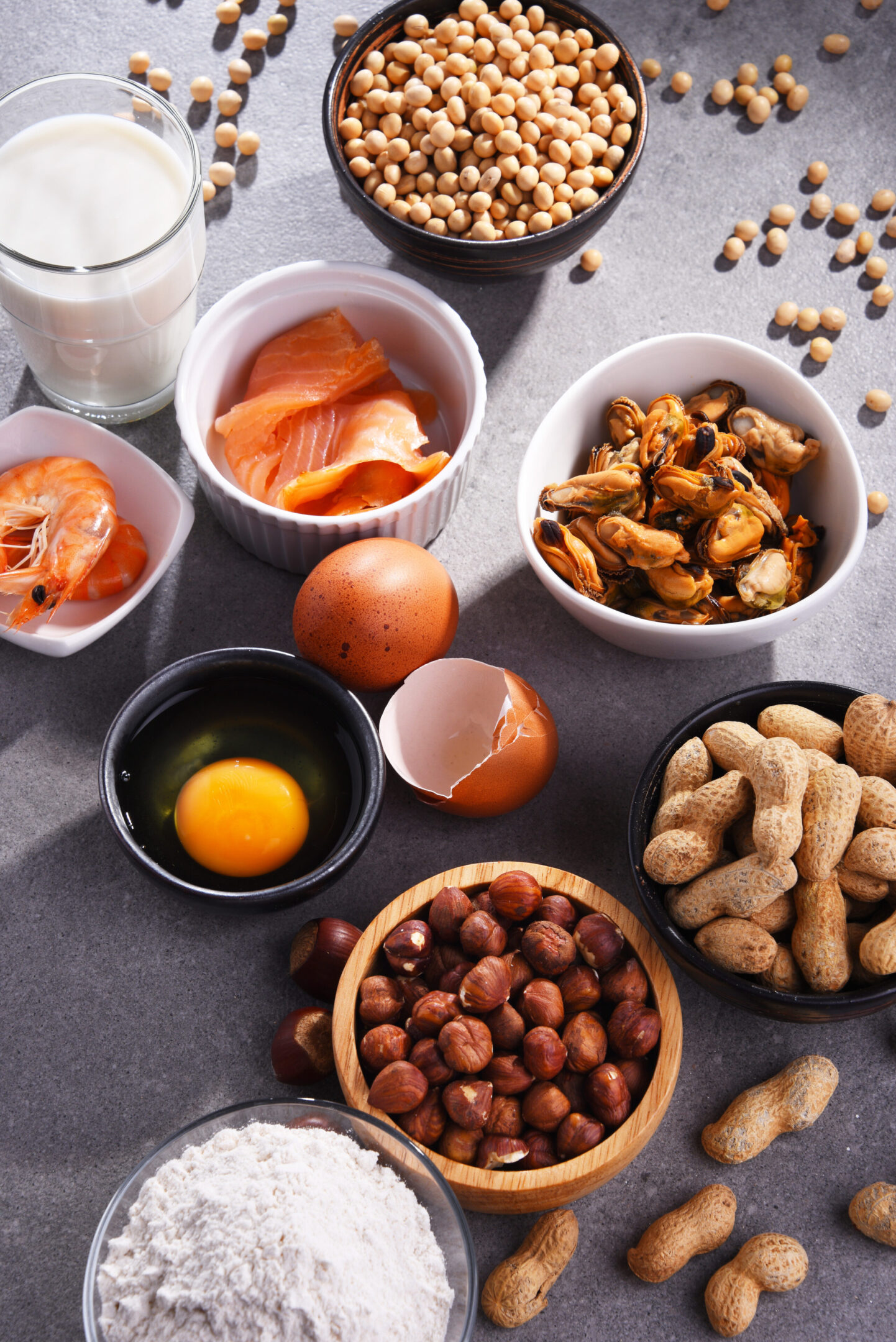 A table topped with bowls of food and cups.