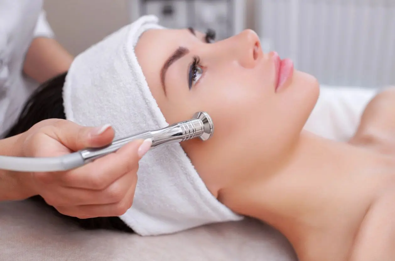 A woman getting her face waxed at the spa