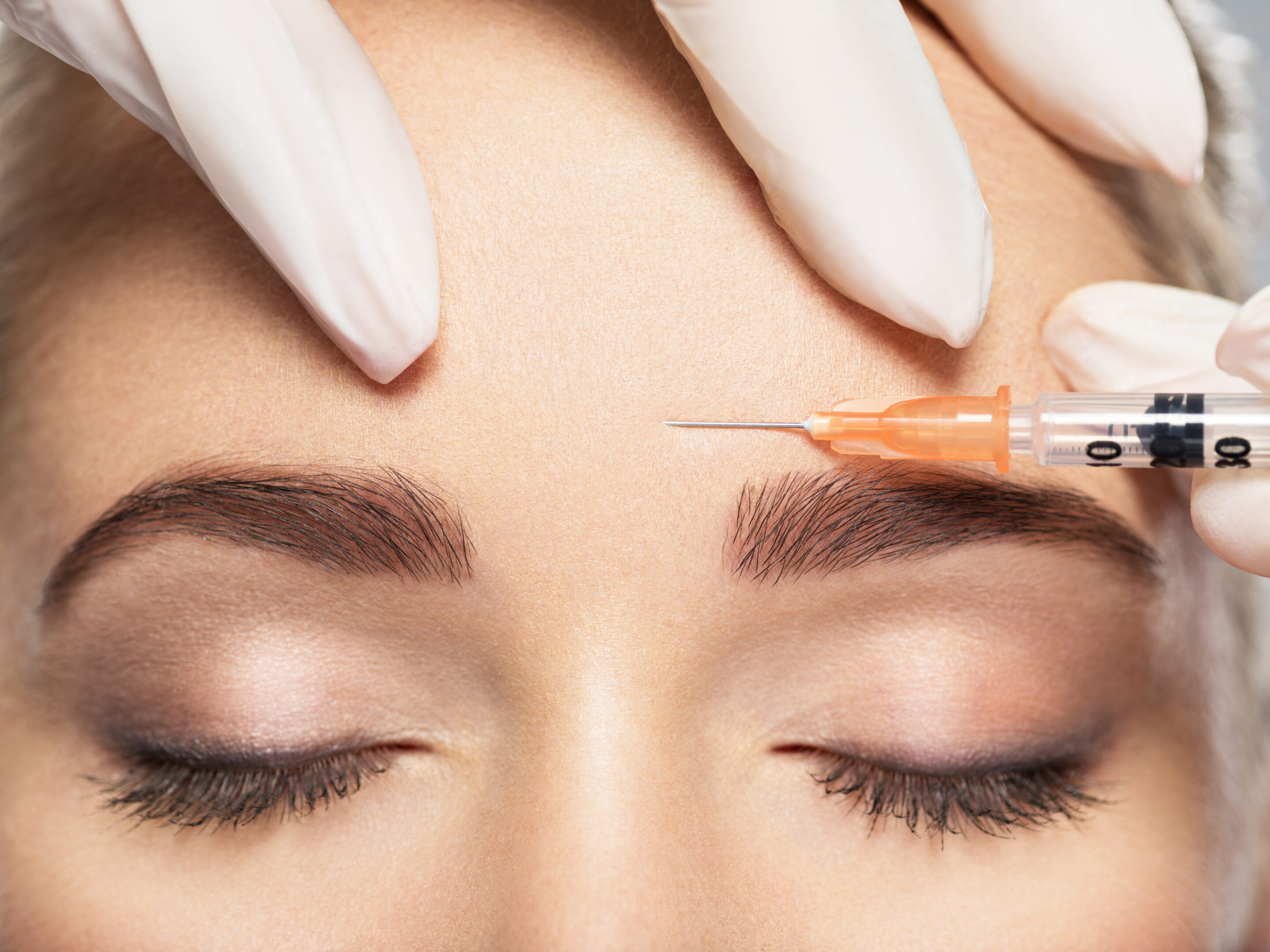 A woman getting an injection in her forehead.