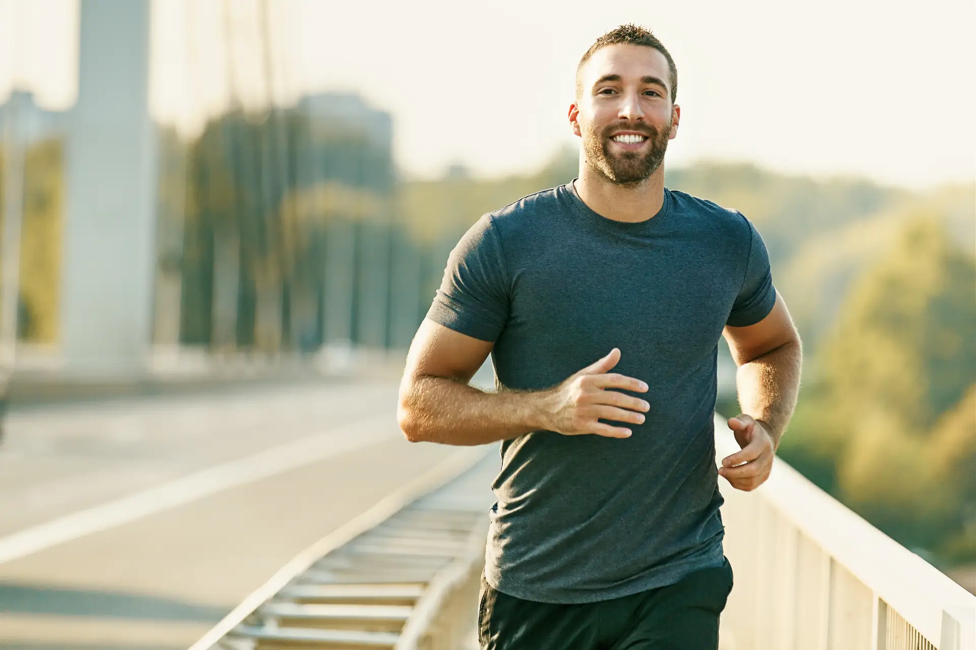 A man running on the side of a bridge.