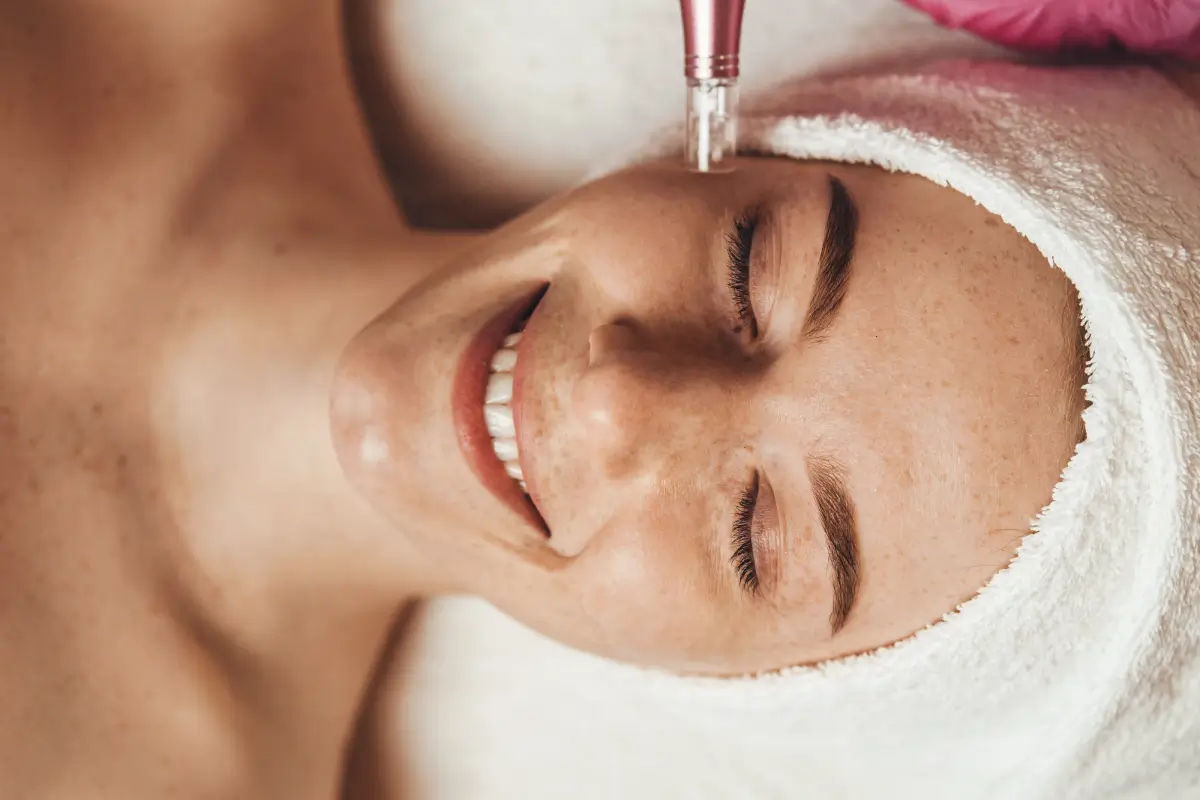 A woman getting her face washed with the help of an electric device.